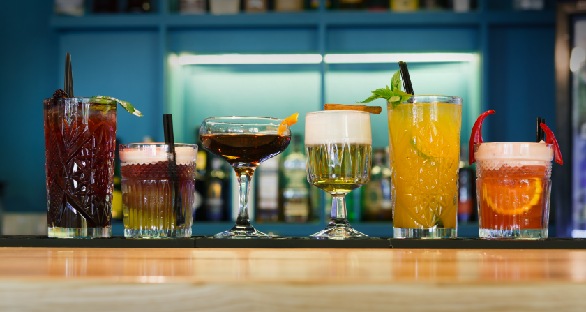 Una serie di drink in fila sul bacone di un bar