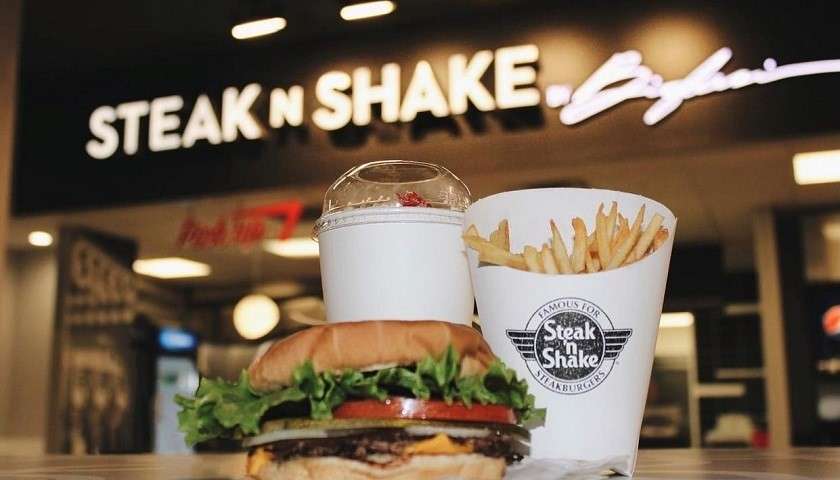 Hamburger, patatine e milkshake sul tavolo di un fast food Steak 'n Shake
