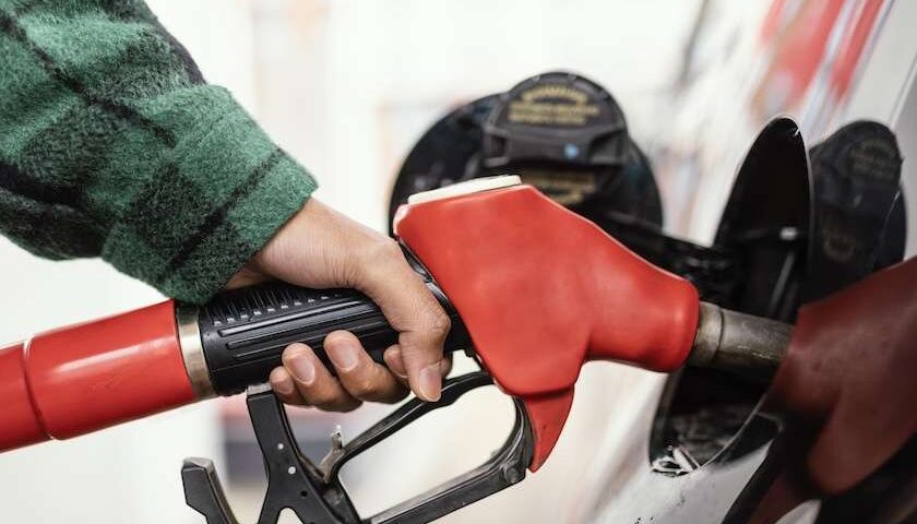 Erogazione carburante con pistola rossa alla pompa, taglio accise bonus carburanti 2026