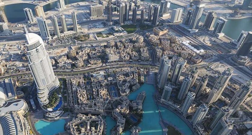 Vista aerea di Dubai con grattacieli e laguna artificiale: città che attira sempre più italiani per lavoro e stipendi elevati.