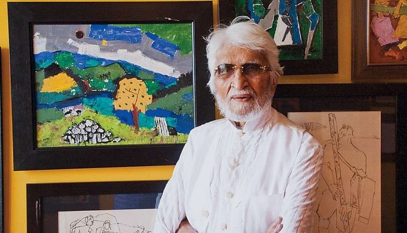 Maqbool Fida Husain posa davanti ad alcune sue opere