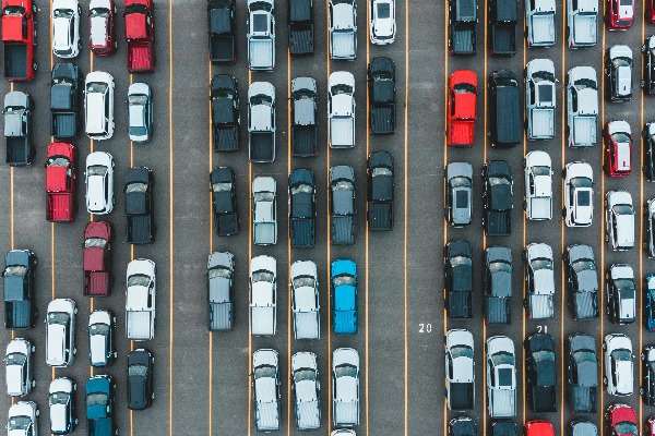 Veduta aerea di un parcheggio con file di auto nuove di diversi colori e modelli