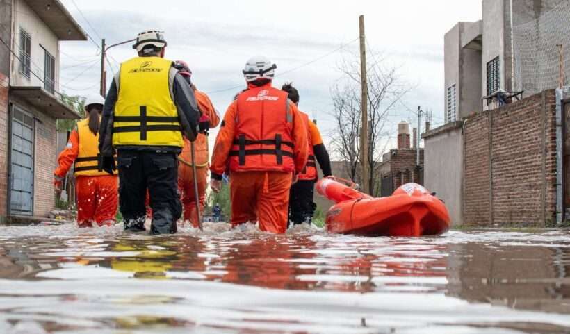 Squadra di soccorso attraversa una strada allagata.