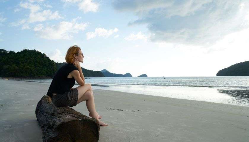 una donna da sola che guarda il mare