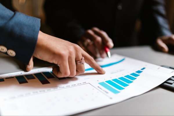 Consulente finanziario analizza grafici e dati di raccolta con un cliente
