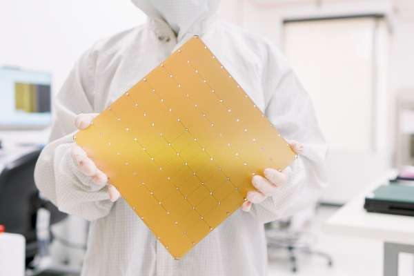 Un tecnico in tuta sterile regge il Wafer-Scale Engine di Cerebras Systems, il chip per intelligenza artificiale più grande mai prodotto commercialmente