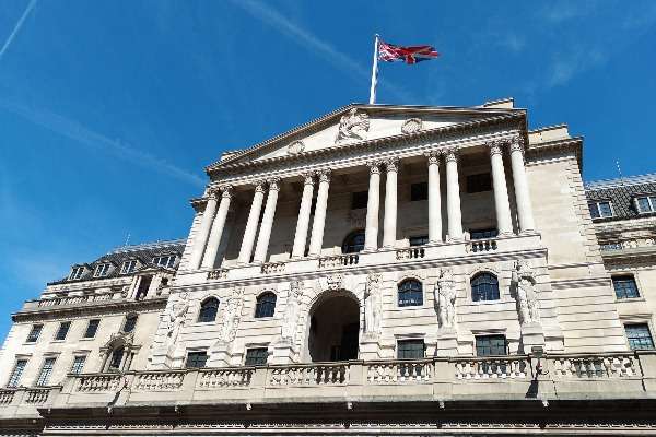 Sede della Banca d'Inghilterra a Londra con bandiera Union Jack, cielo blu sullo sfondo