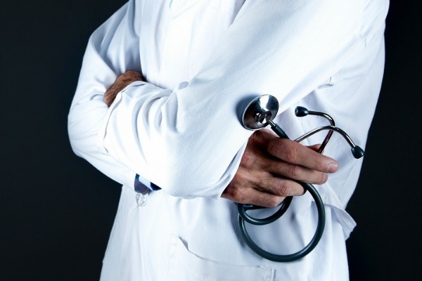 Un medico in camice con lo stetoscopio in mano