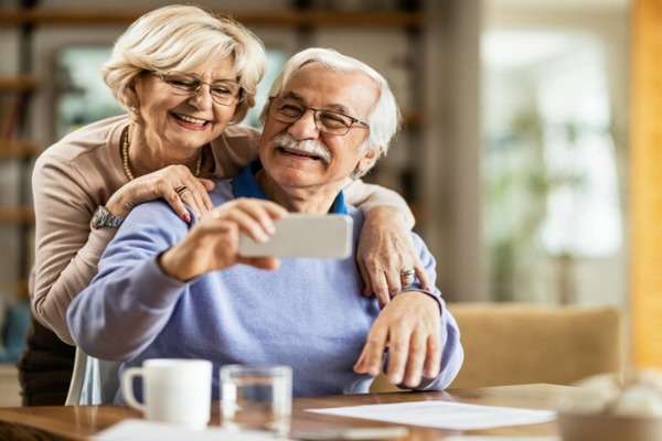 Coppia di pensionati sorridenti con smartphone – no tax area pensioni 2026 limiti reddito