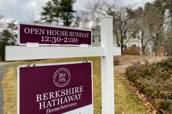 Cartello di Berkshire Hathaway HomeServices con avviso di open house domenicale, esposto davanti a un'abitazione residenziale.