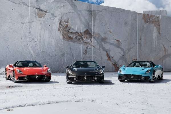Tre Maserati MC20 Cielo spider in rosso, nero e celeste parcheggiate davanti a una parete di marmo bianco di Carrara