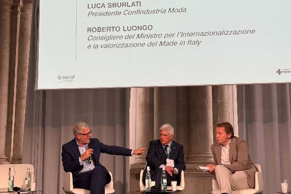 Tavola rotonda al Congresso Internazionale SAMAB 2026: Luca Sburlati, Presidente di Confindustria Moda, e Roberto Luongo, Consigliere del Ministro per l'Internazionalizzazione e la valorizzazione del Made in Italy, a confronto sul palco di Palazzo Giureconsulti a Milano.