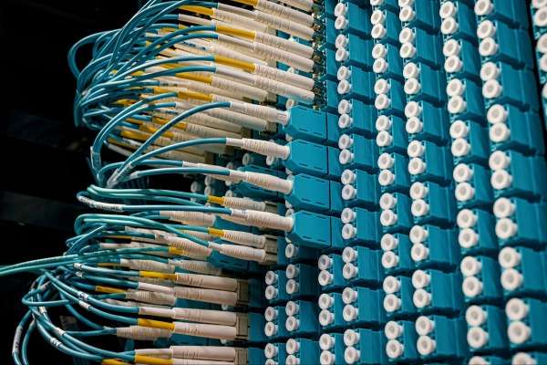 Pannello di connessioni in fibra ottica con cavi turchese e giallo in un data center