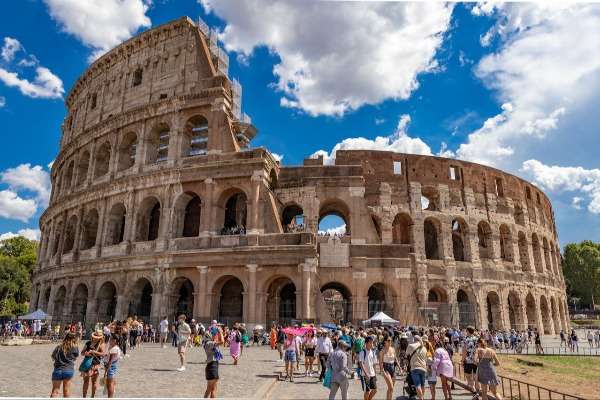 Turisti affollano l'area esterna del Colosseo a Roma in una giornata estiva