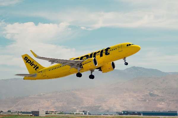 Un aereo Spirit Airlines in livrea gialla decolla in una giornata nuvolosa