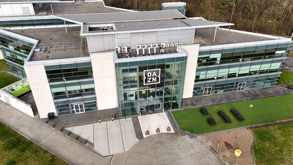 Vista aerea della sede DAZN con logo aziendale sulla facciata in vetro