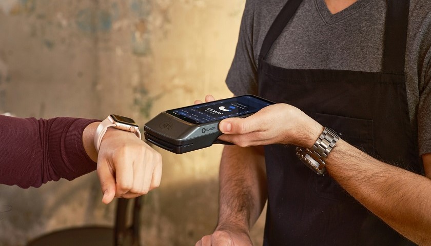 Una persona paga al Pos in un bar con lo smartwatch