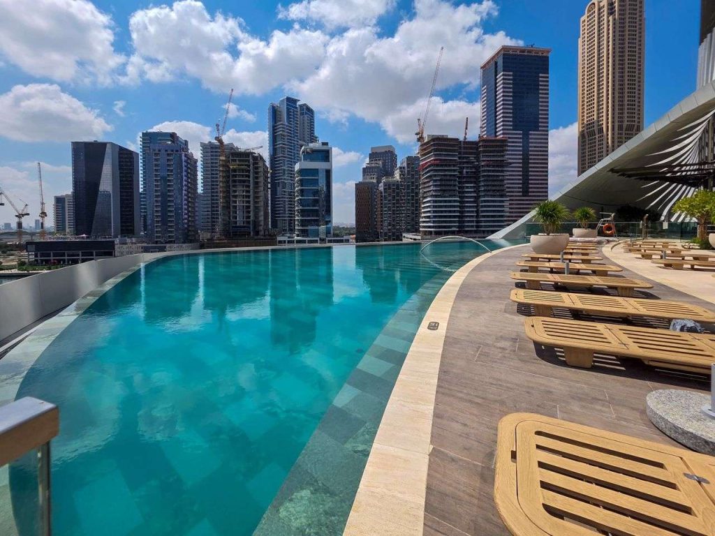 Piscina a sfioro su un grattacielo con vista sullo skyline di Dubai in costruzione