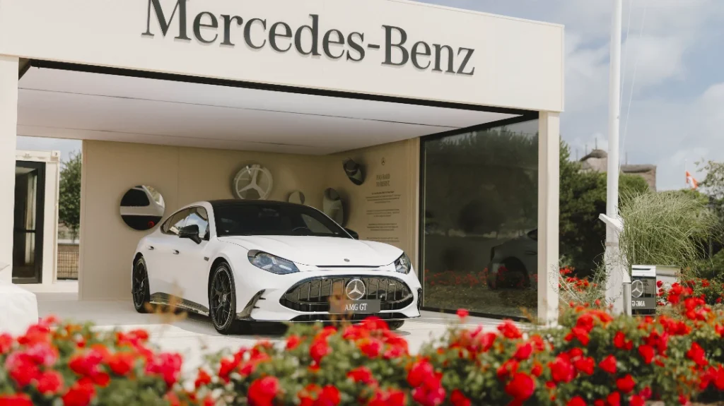 Mercedes-AMG GT bianca esposta davanti al padiglione del marchio Mercedes-Benz, tra siepi di rose rosse