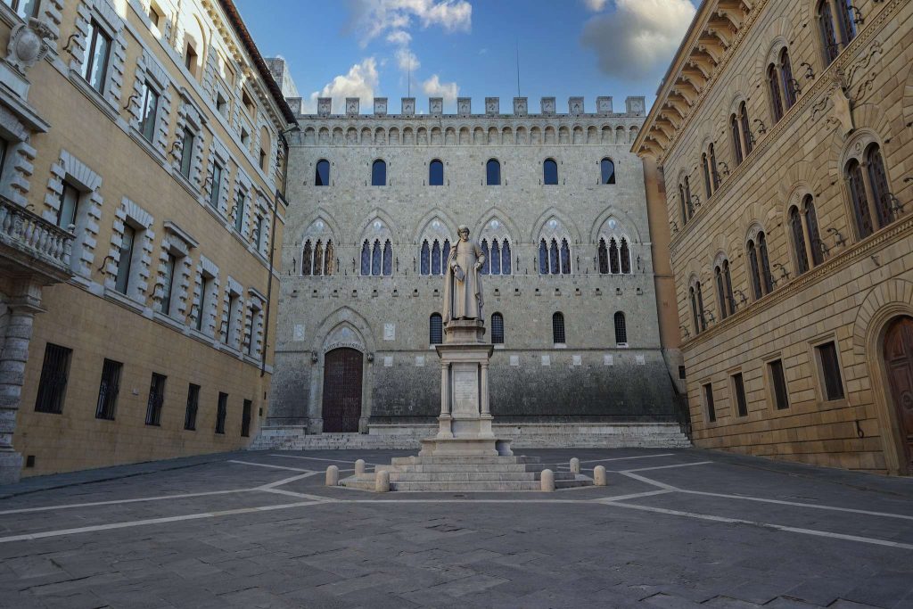 Facciata gotica di Palazzo Salimbeni, sede storica di MPS, con la statua di Sallustio Bandini in primo piano