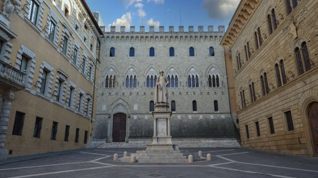 Facciata gotica di Palazzo Salimbeni, sede storica di MPS, con la statua di Sallustio Bandini in primo piano