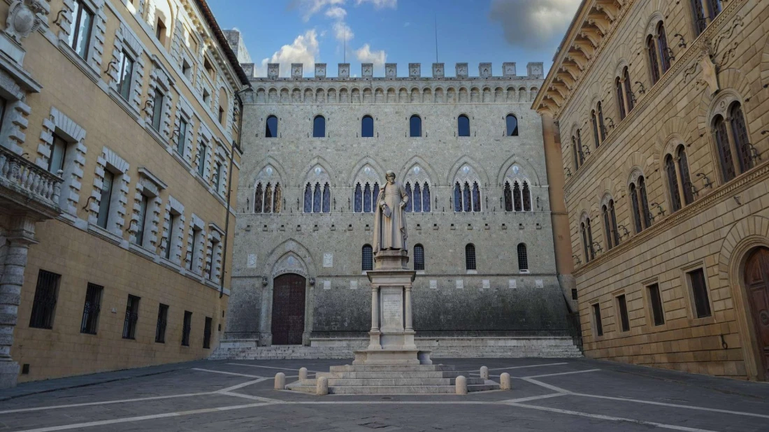 Facciata gotica di Palazzo Salimbeni, sede storica di MPS, con la statua di Sallustio Bandini in primo piano