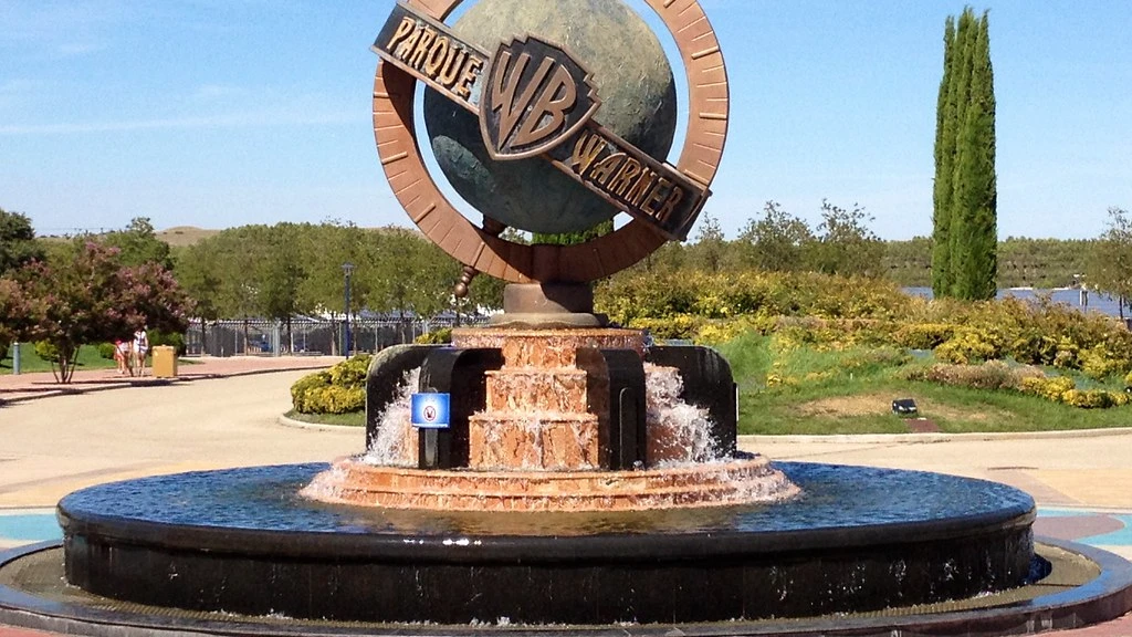 Fontana monumentale con il logo Warner Bros all'ingresso del parco a tema Parque Warner Madrid