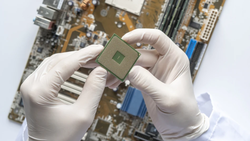 Le mani con i guanti bianchi, in primo piano, di un tecnico, mentre maneggia un chip di memoria