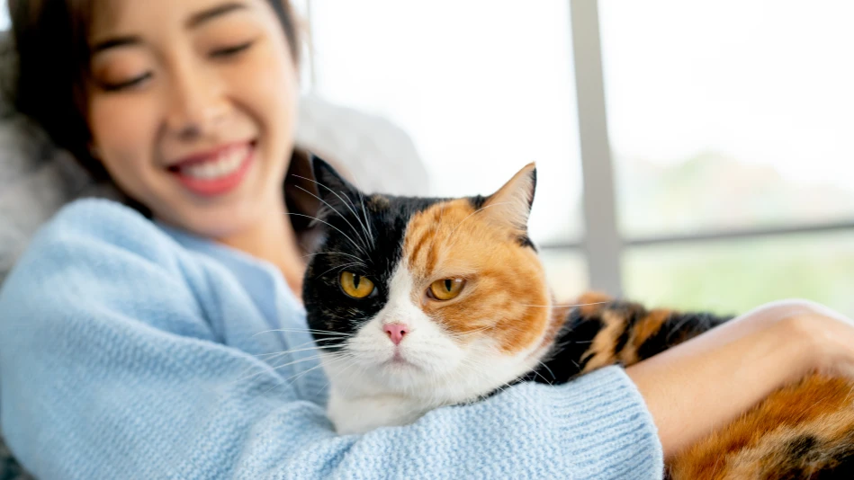 Una ragazza sorridente con in braccio il suo gatto