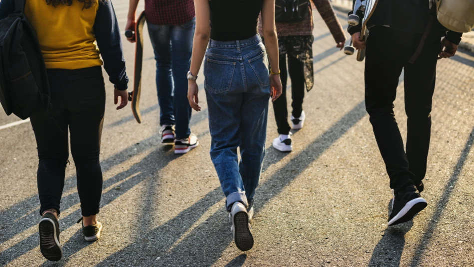 Un gruppo di giovani cammina sul fare del tramonto, su una banchina del porto. Ripresi di spalle (By Rawpixel)