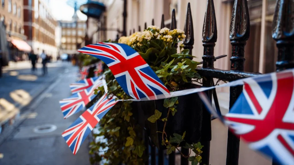 Bandierine Union Jack appese a una ringhiera in ferro battuto su una strada londinese. La sterlina resta sotto osservazione mentre la Banca d'Inghilterra valuta i prossimi passi sui tassi