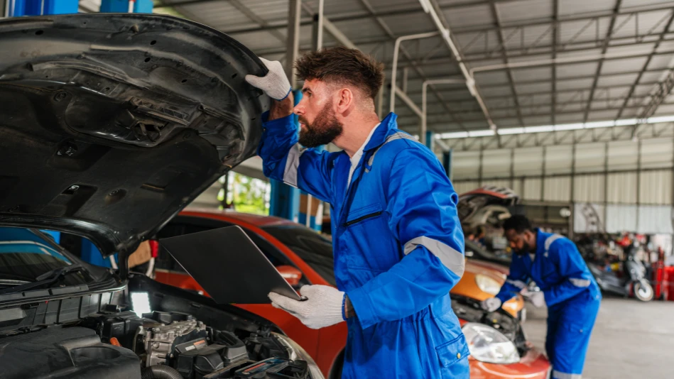 Automobili all'interno di un officina mentre due meccanici fanno i controlli al motore