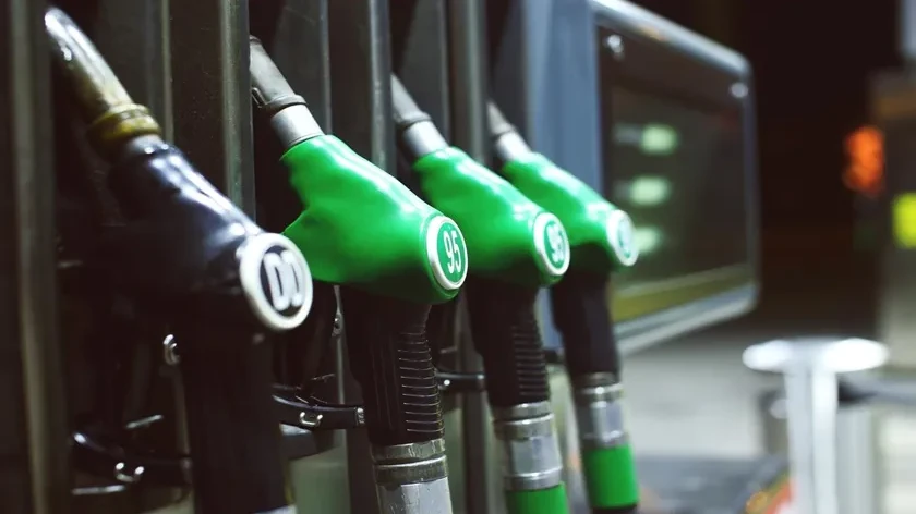 Pompe di benzina con erogatori verdi e neri, indicati per carburanti diversi, in una stazione di servizio.